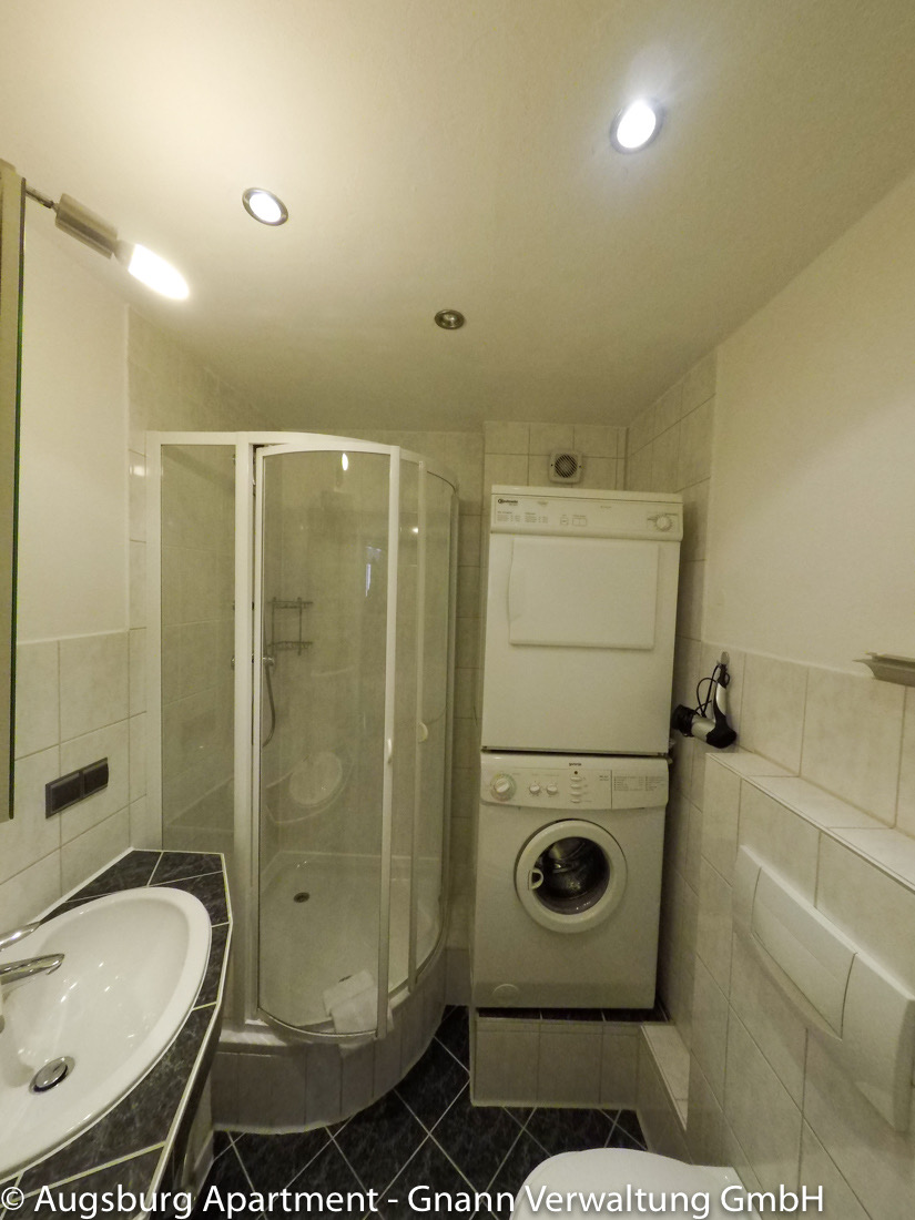 Łazienka z prysznicem i pralką w umeblowanym apartamencie w Augsburgu