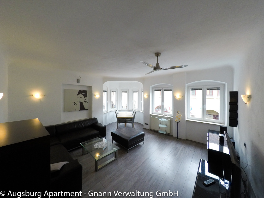 Wohnbereich mit Sofa und Essplatz in einem möblierten Apartment in Augsburg