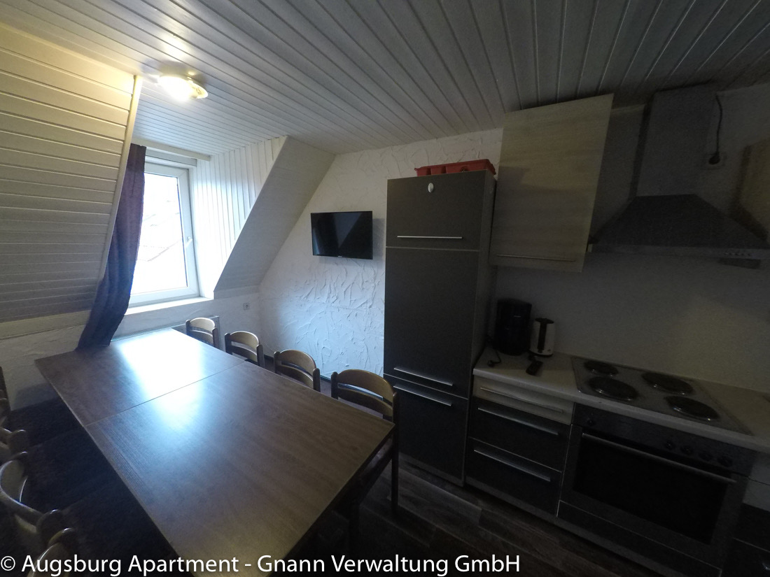 Kitchen-diner with a large dining table in a workers' apartment in Augsburg